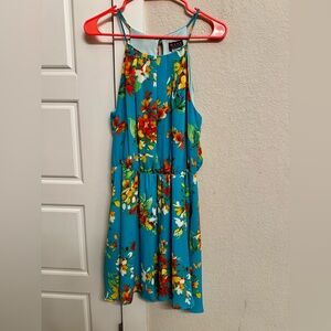 Turquoise colored sundress with flower detail.